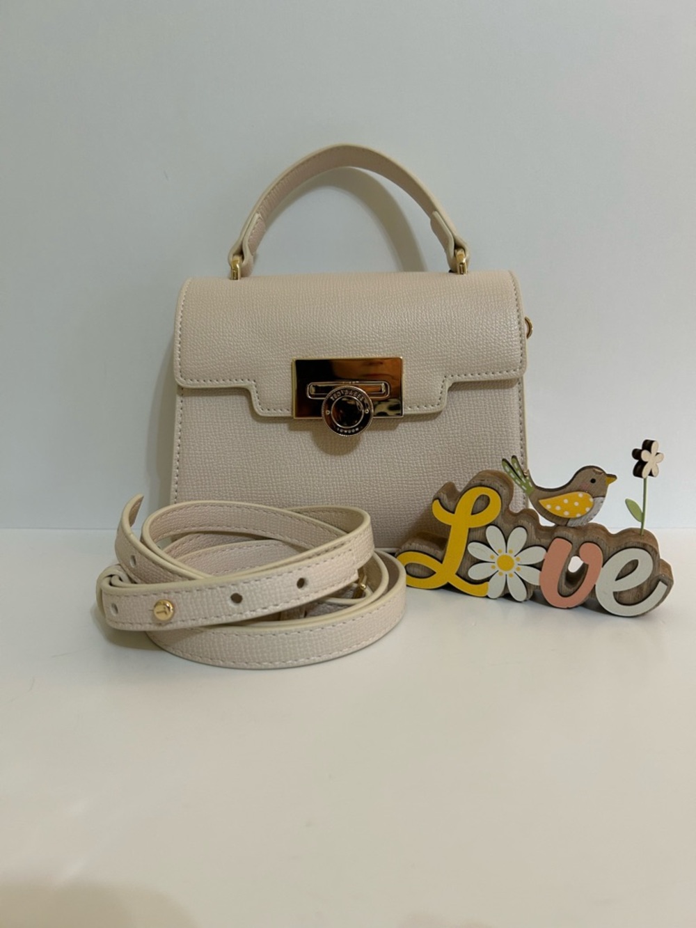 Ted Baker Cream Top-Handle Crossbody Bag With Gold Accents.